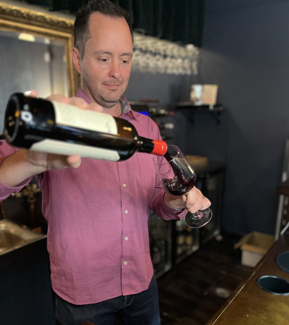 Bartender serving wine at bar